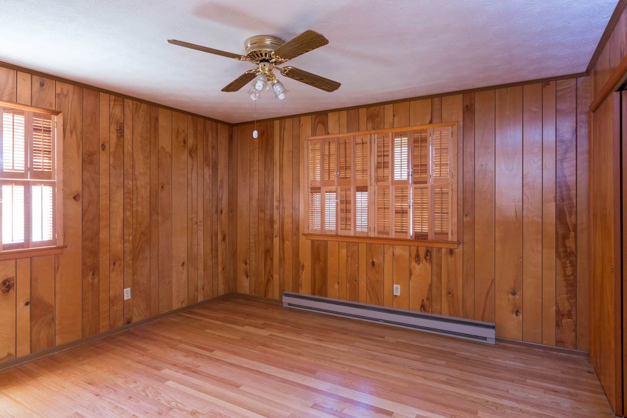 512 Curry Road Mount Solon, VA 22843 - Photo 6 of 26 an empty room with wooden floor and windows with curtains