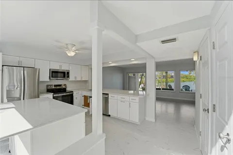 a kitchen with granite countertop a sink stove and refrigerator