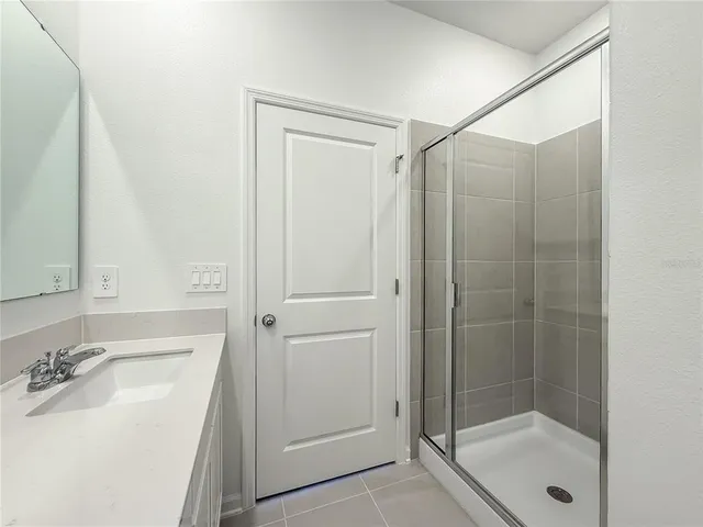 a bathroom with a sink a shower and mirror