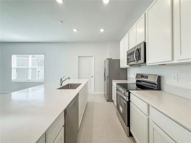 a kitchen with stainless steel appliances granite countertop a sink and a stove