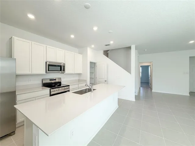 a large white kitchen with stainless steel appliances