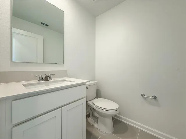 a bathroom with a toilet sink vanity and mirror