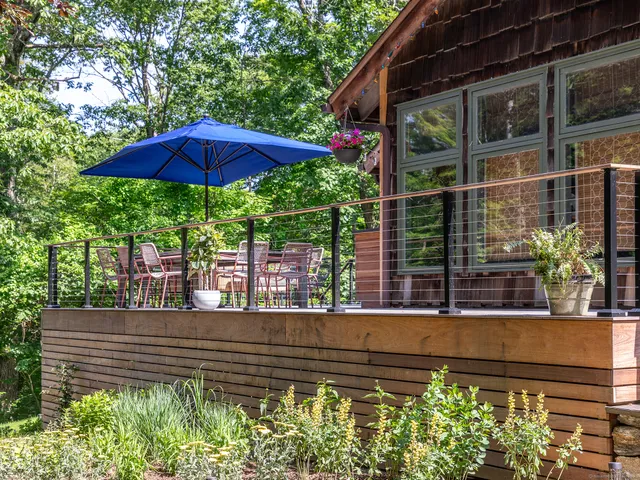 a view of a deck with a table and chairs under an umbrella