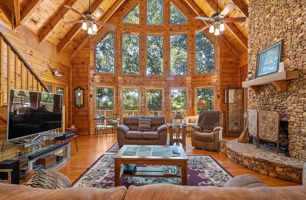 a living room with furniture a flat screen tv and a floor to ceiling window