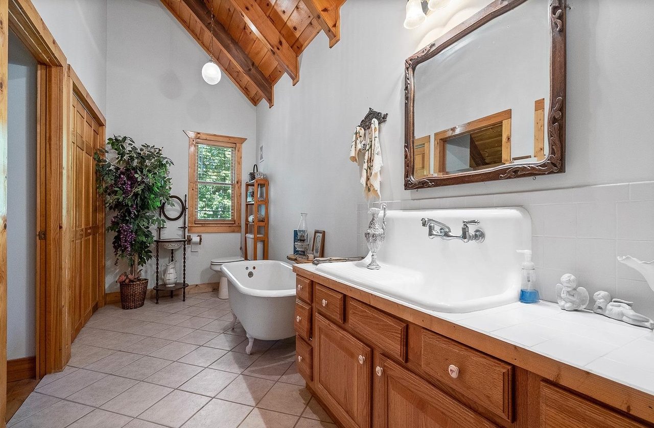 2221 County Road 6 Wedowee, AL 36278 - Photo 24 of 40 a spacious bathroom with a double vanity sink a mirror and a bathtub