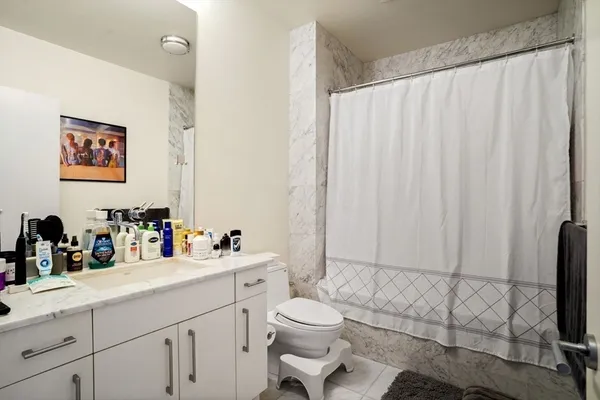 a bathroom with a sink a toilet and shower curtain