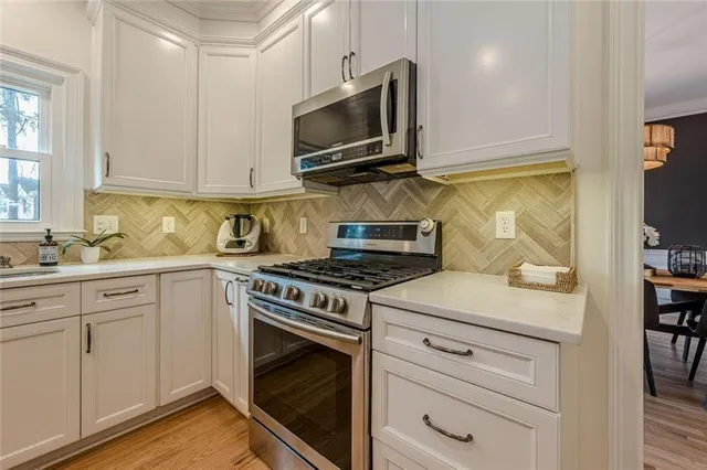 a kitchen with white cabinets and appliances
