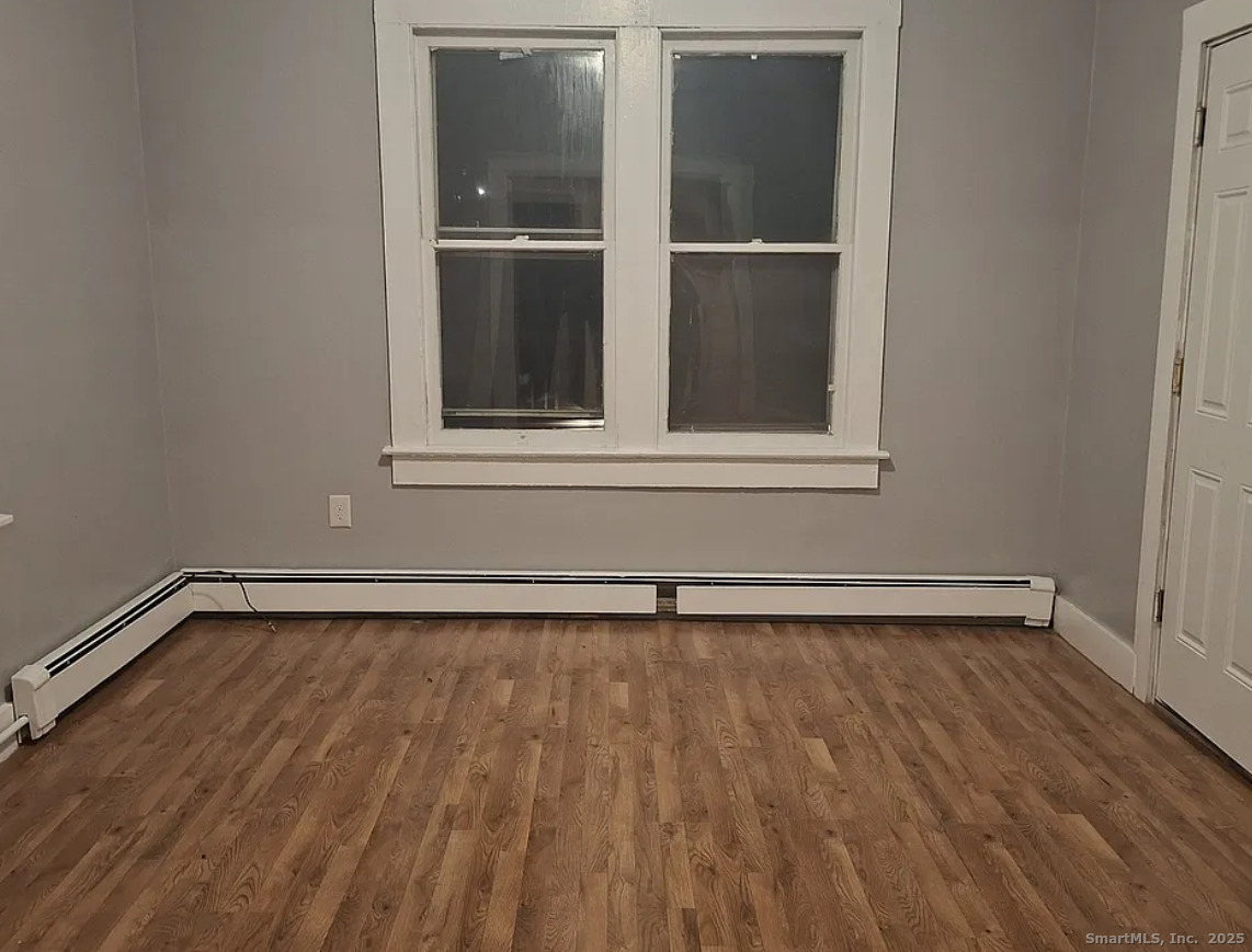 1403 Corbin Avenue New Britain, CT 06053 - Photo 4 of 6 a view of an empty room with wooden floor and a window