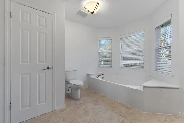 a spacious bathroom with a bathtub and a toilet