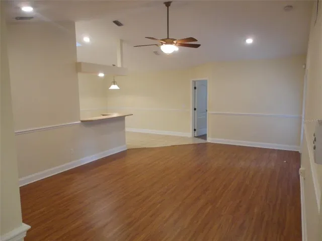 a view of a livingroom with a ceiling fan and wooden floor