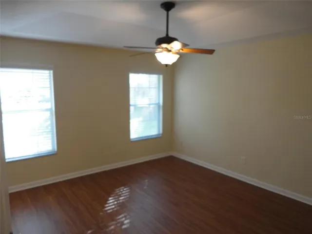 a view of a room with wooden floor and windows