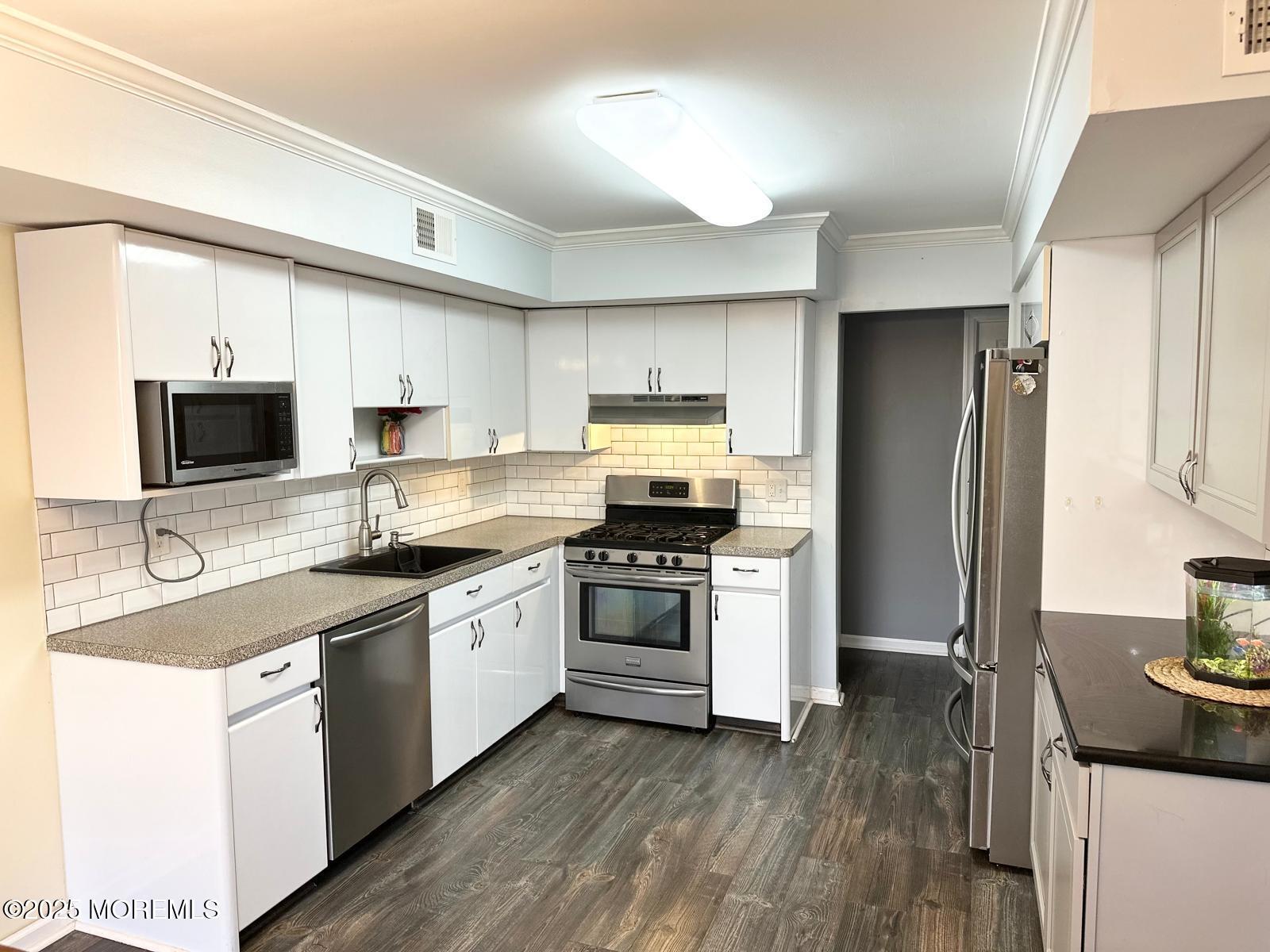 49 White Swan Way Brick, NJ 08723 - Photo 12 of 30 a kitchen with stainless steel appliances a stove a sink and a refrigerator