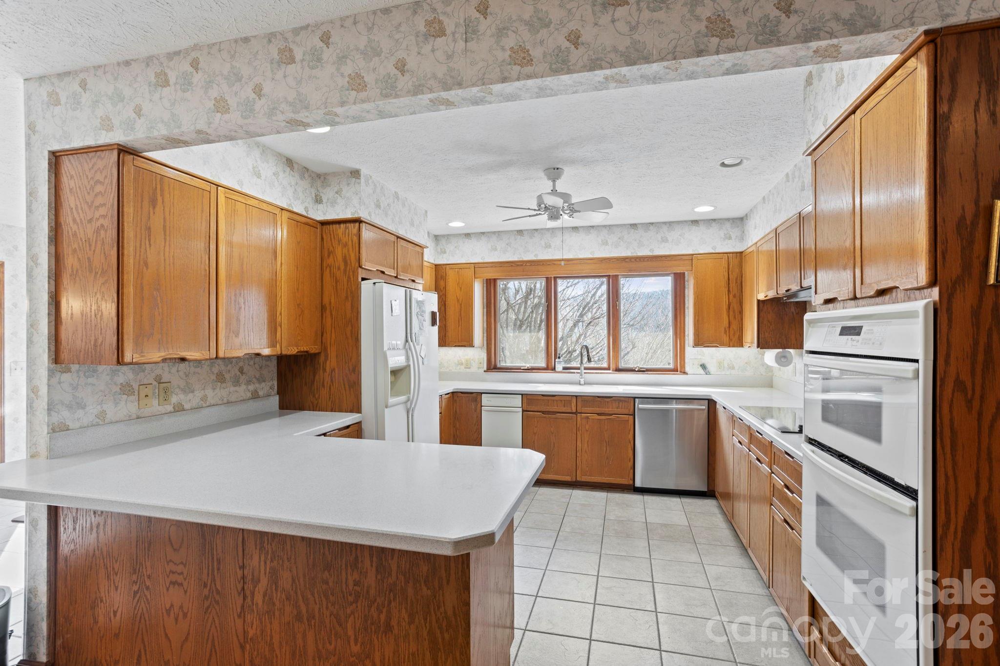404 Browning Road Hendersonville, NC 28791 - Photo 11 of 46 a kitchen with stainless steel appliances granite countertop a sink and cabinets