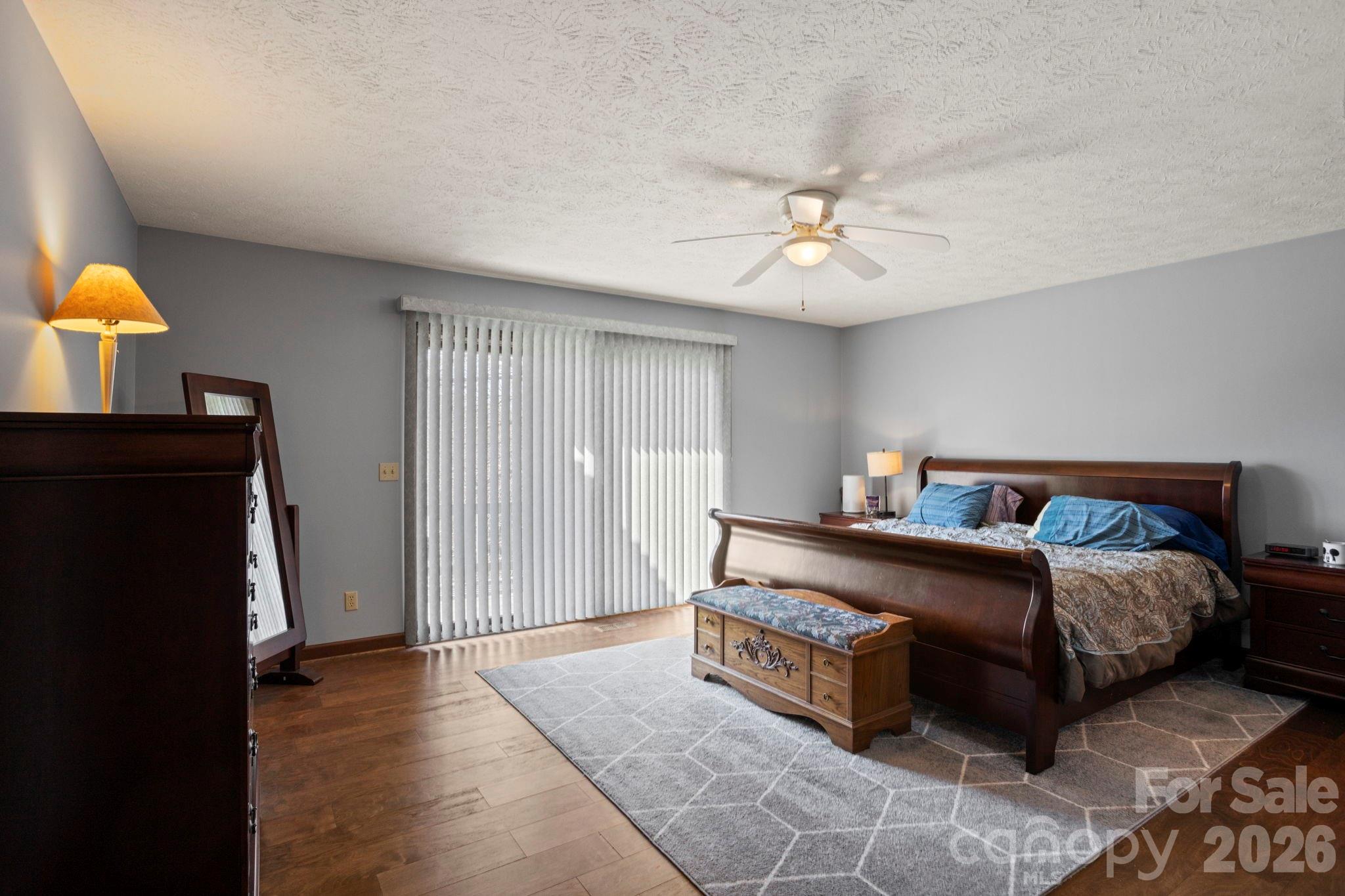404 Browning Road Hendersonville, NC 28791 - Photo 16 of 46 a spacious bedroom with a bed and a chandelier