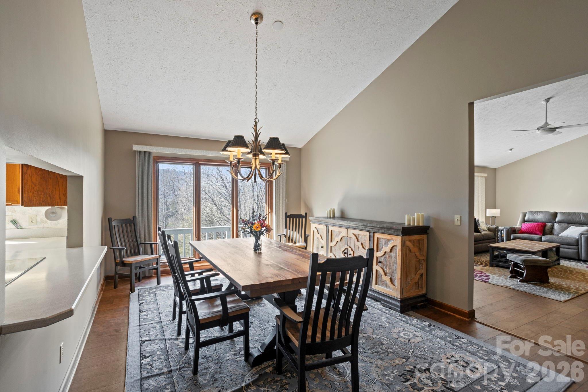 404 Browning Road Hendersonville, NC 28791 - Photo 9 of 46 a view of a dining room and livingroom with furniture wooden floor a chandelier