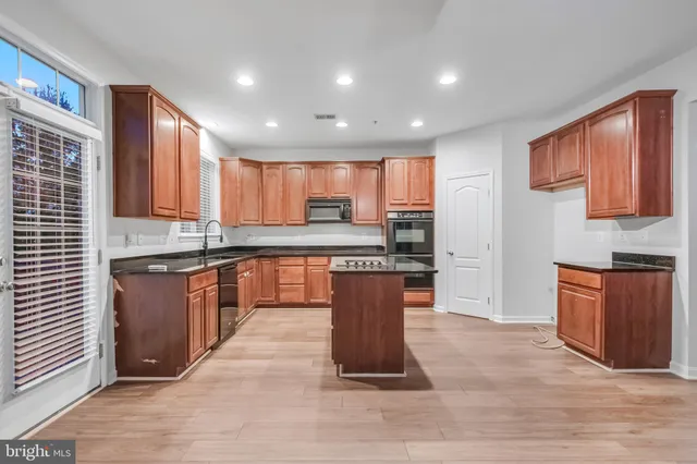 a kitchen with stainless steel appliances granite countertop a stove sink and cabinets