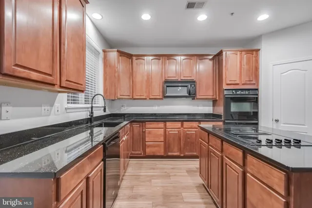 a kitchen with stainless steel appliances granite countertop a sink stove and cabinets