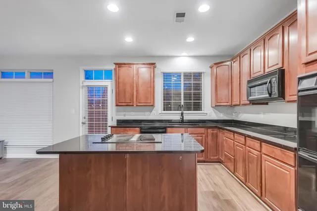a kitchen with stainless steel appliances granite countertop a sink stove and cabinets