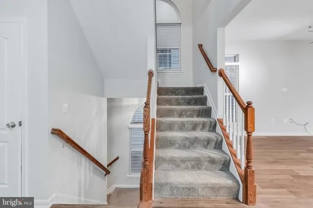 a view of staircase with white walls and white door