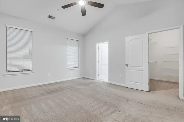 an empty room with chandelier fan
