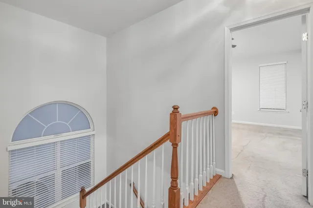a view of staircase with railing and white walls
