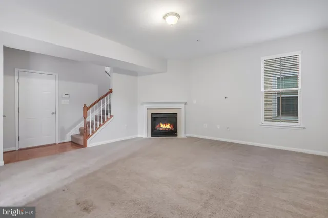 a view of an empty room with a fireplace and a window