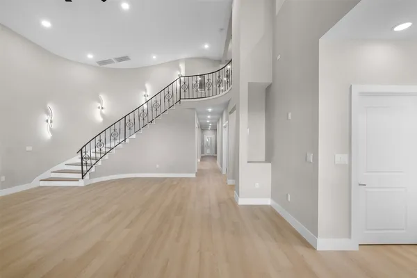 a large white kitchen with stainless steel appliances granite countertop a refrigerator and a stove top oven