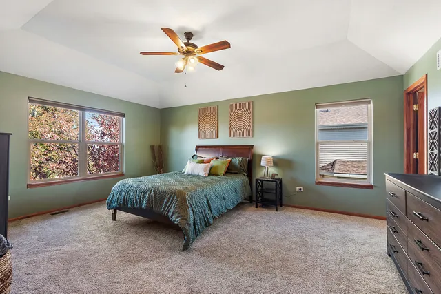 a bedroom with a bed and a dresser next to a window