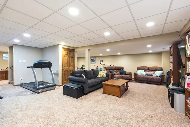 a living room with furniture and a gym machine