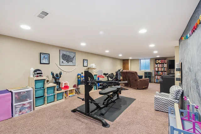 a living room with furniture gym equipment and a view of kitchen