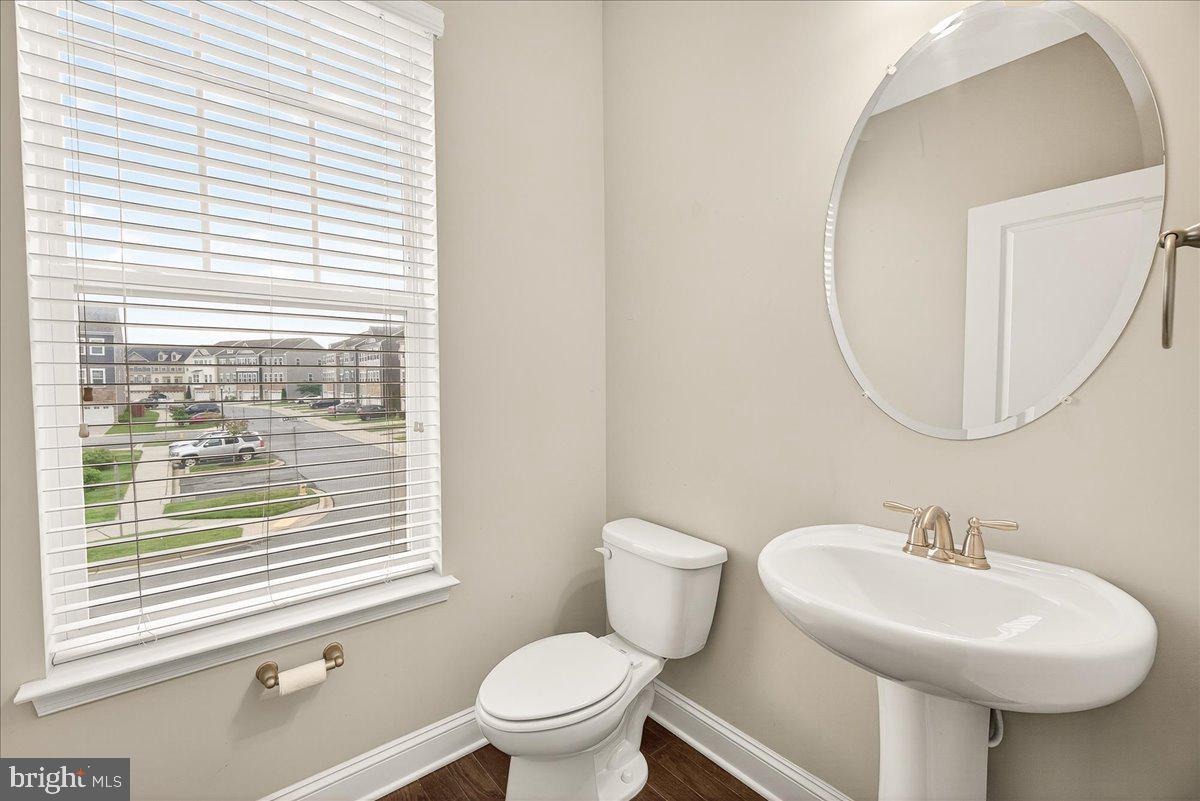 4654 Cambria Road Frederick, MD 21703 - Photo 16 of 55 a bathroom with a sink a mirror a toilet and a window