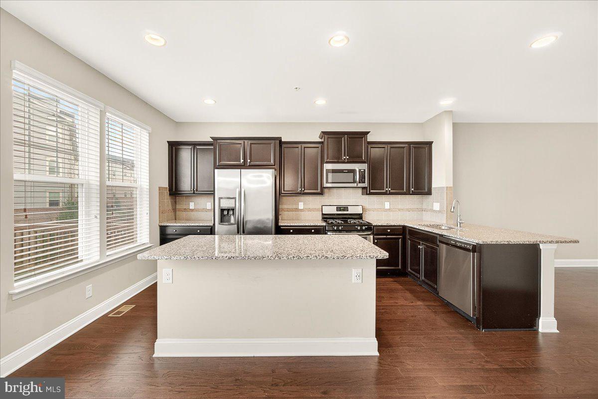 4654 Cambria Road Frederick, MD 21703 - Photo 23 of 55 a large kitchen with kitchen island a large counter top space a sink stainless steel appliances and cabinets
