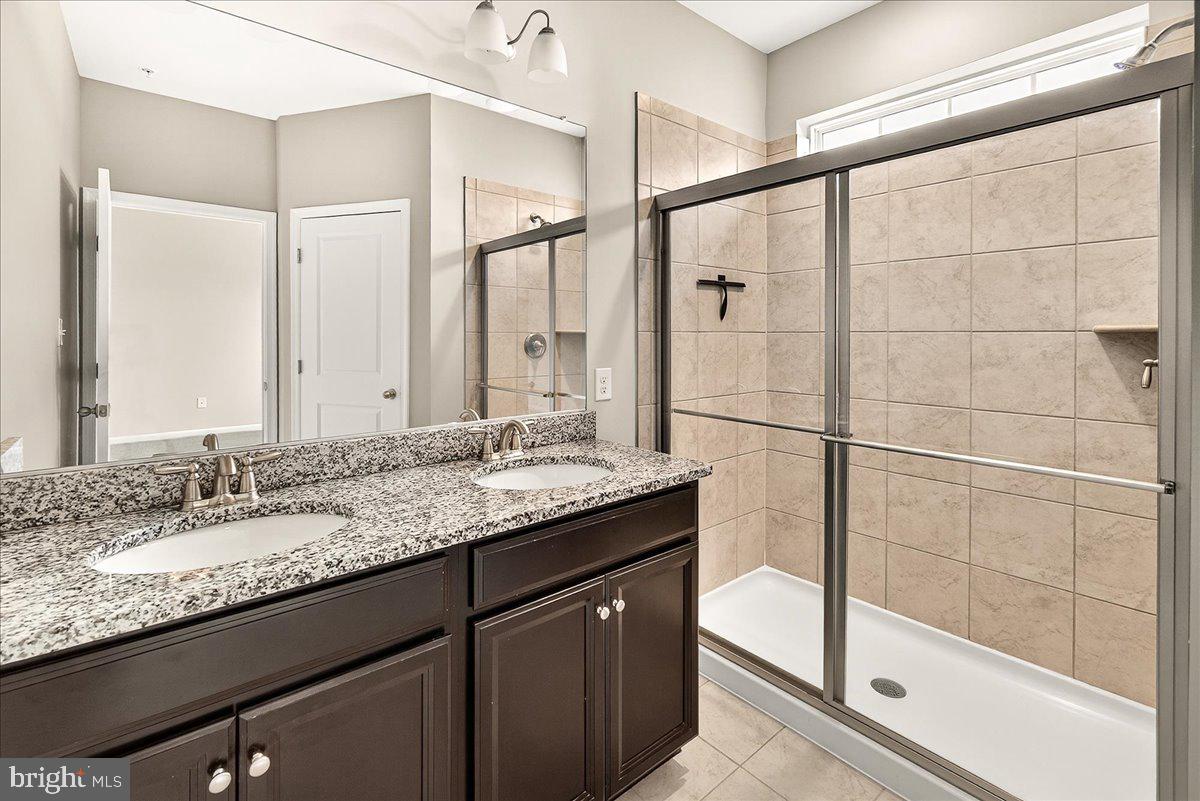 4654 Cambria Road Frederick, MD 21703 - Photo 34 of 55 a bathroom with a granite countertop sink mirror and shower