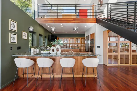 a dining table chairs and chandelier in wooden floor