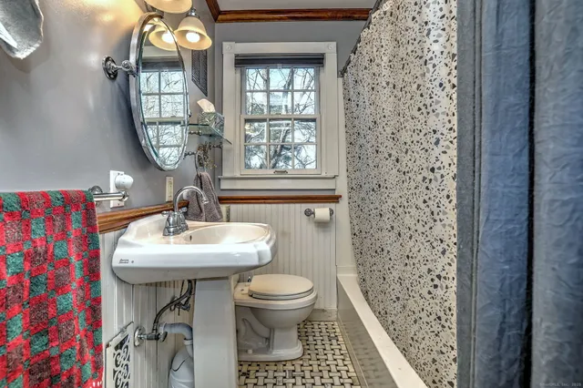 a bathroom with a sink a toilet and a mirror