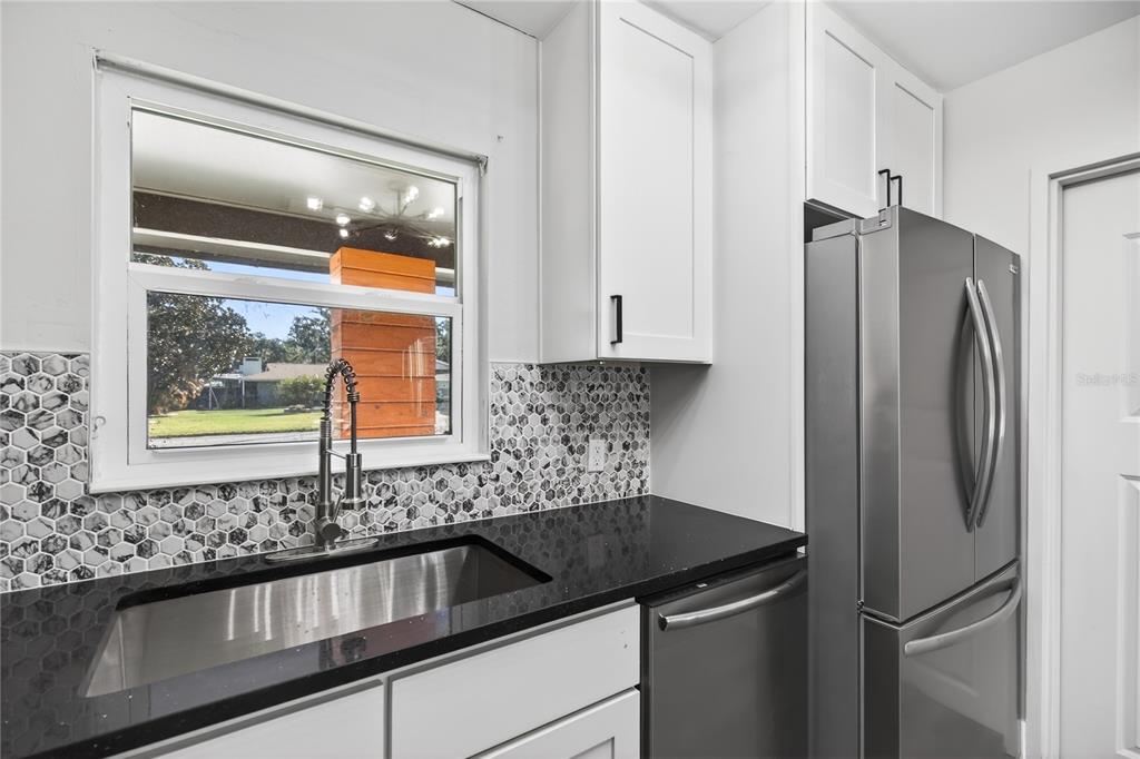 1503 Canal Court Tavares, FL 32778 - Photo 13 of 41 a kitchen with stainless steel appliances granite countertop a refrigerator and a sink
