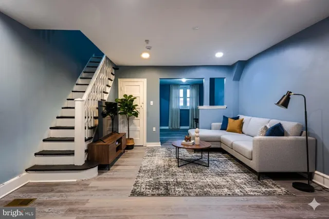 a living room with furniture and stairs