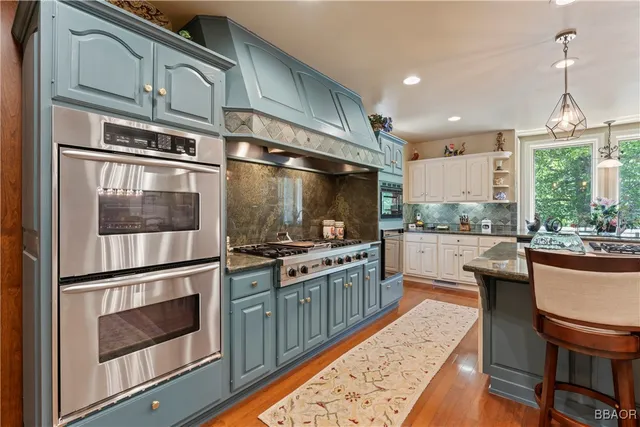 a kitchen with stainless steel appliances granite countertop a stove and cabinets