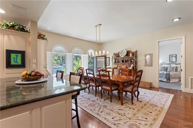a view of a dining room and livingroom with furniture wooden floor a chandelier
