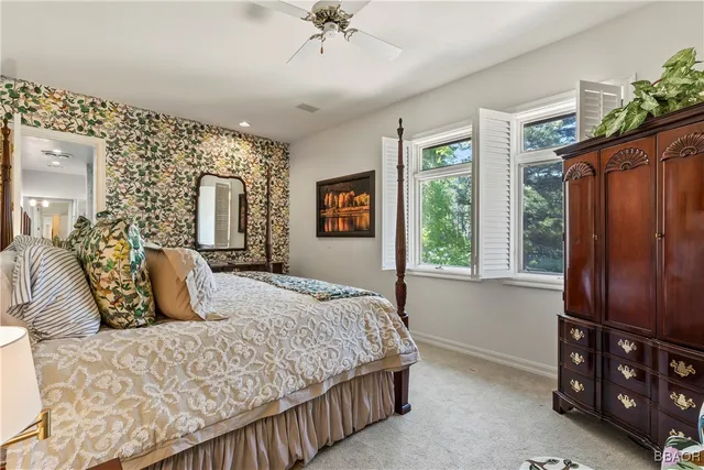 a bedroom with a bed a dresser next to a window