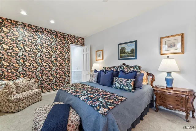 a bedroom with bed and a lamp on dresser