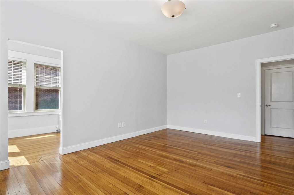 91 Verndale Street, Unit 1 Brookline, MA 02446 - Photo 12 of 16 a view of an empty room with wooden floor and a window