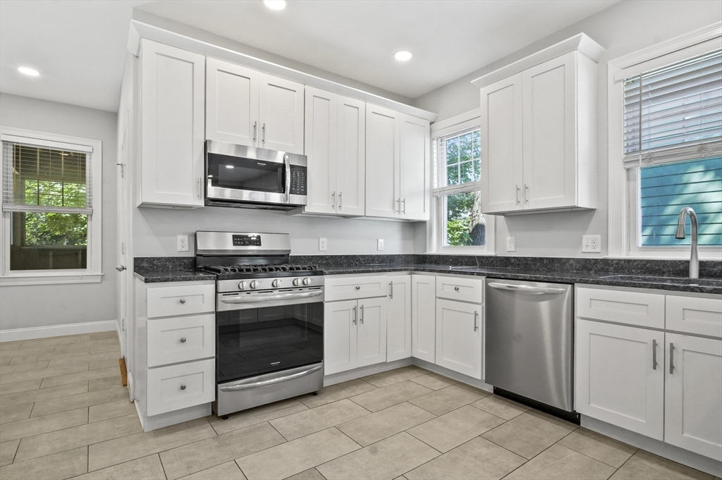 91 Verndale Street, Unit 1 Brookline, MA 02446 - Photo 4 of 16 a kitchen with stainless steel appliances granite countertop a stove a sink and a microwave