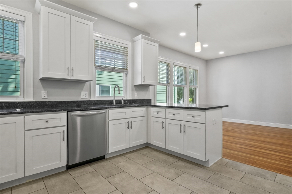 91 Verndale Street, Unit 1 Brookline, MA 02446 - Photo 5 of 16 a kitchen with granite countertop white cabinets white appliances with a sink and dishwasher