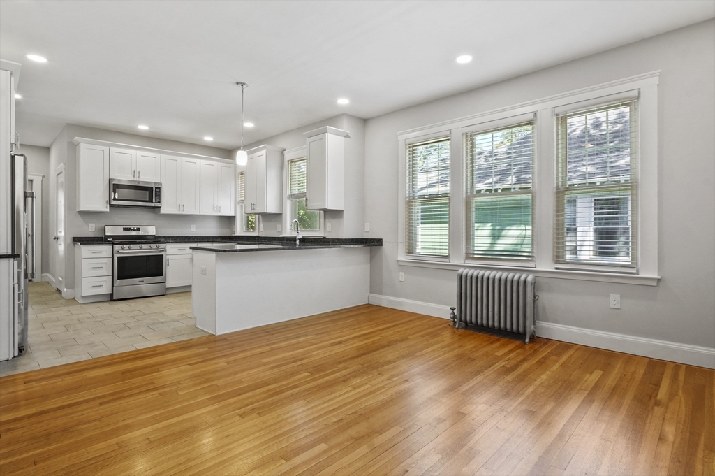 91 Verndale Street, Unit 1 Brookline, MA 02446 - Photo 6 of 16 a view of kitchen with granite countertop cabinets and wooden floor