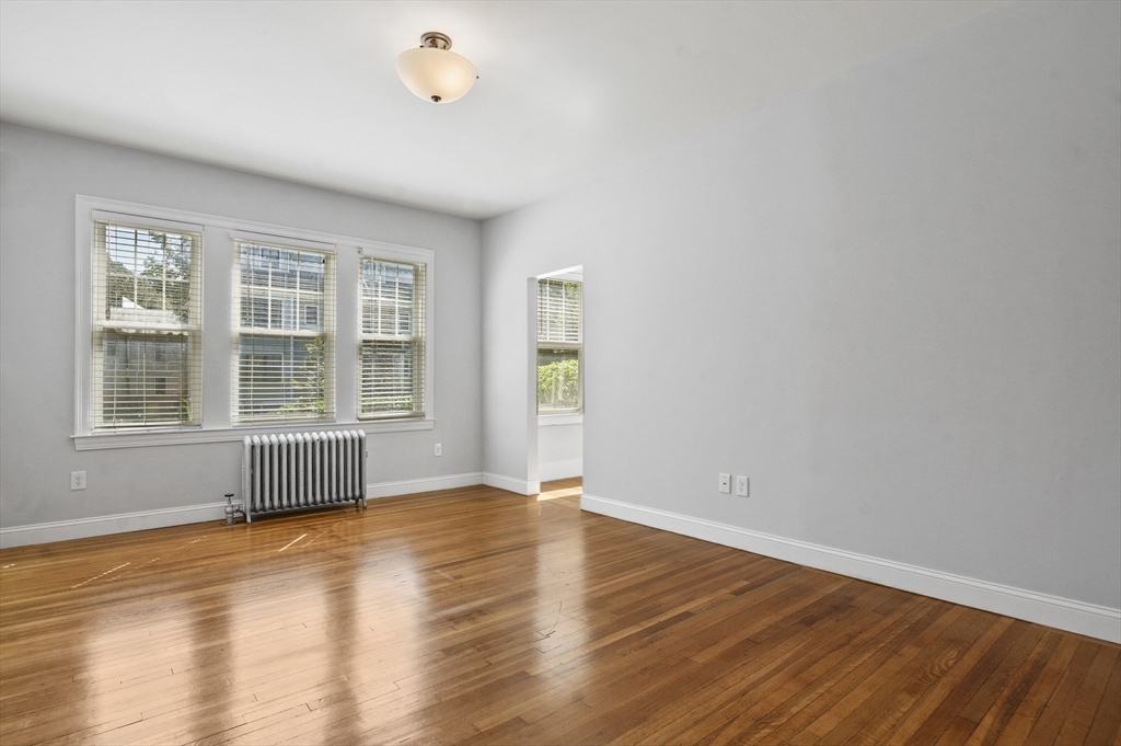 91 Verndale Street, Unit 1 Brookline, MA 02446 - Photo 10 of 16 a view of an empty room with wooden floor and a window