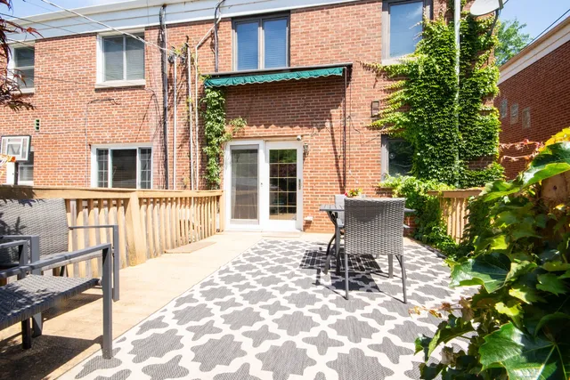 a view of a patio with a table and chairs and potted plants