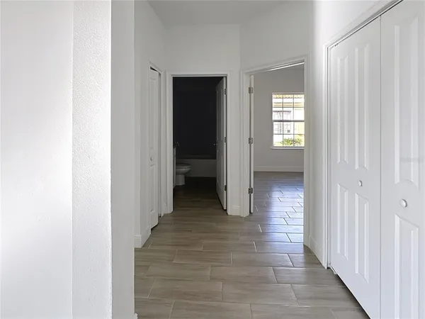 a view of a hallway with wooden floor and closet