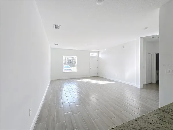a view of an empty room and wooden floor