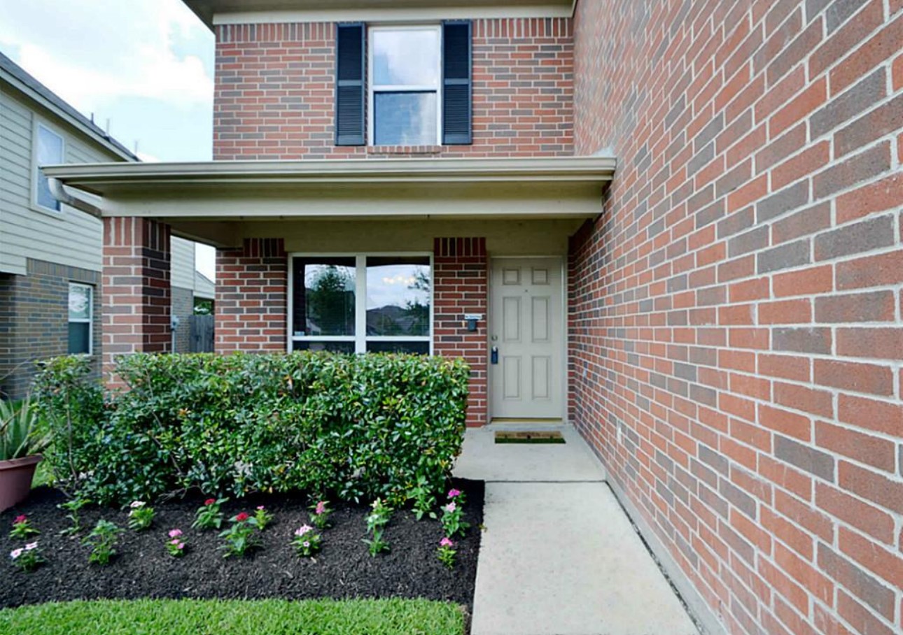 20606 Ricewood Village Trail Katy, TX 77449 - Photo 2 of 17 a view of a brick building with potted plants